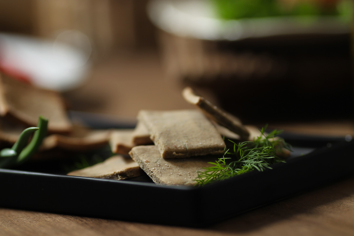 Browned crackers with a sprig of dill beside them.